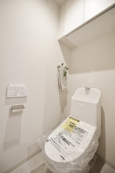 TOTO製のウォシュレット付のトイレ新規交換致しました。上部吊戸棚付ですので、洗剤類やストック類なども収納できすっきりとした清潔感のある空間を保てます。