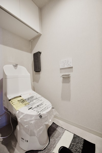 TOTO製のウォシュレット一体型のトイレも新規交換致しました。上部には吊戸棚も設置しましたので、お掃除用品やストックなども収納でき、スッキリとした空間が保てます。