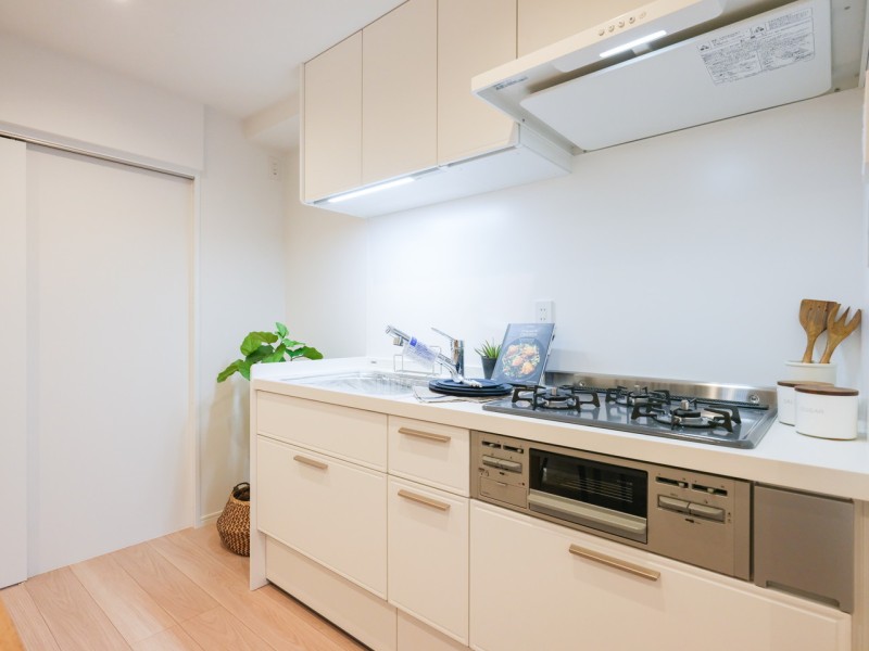 収納力が頼もしい壁付けタイプのシステムキッチンです。お部屋に調和する爽やかなホワイトカラーで仕上げました。