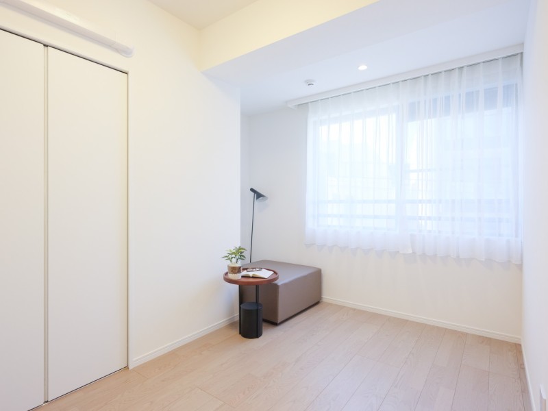 窓から温かな自然光が差し込む洋室1です。クローゼット付きのため、居住スペースを広々とお使いいただけます。