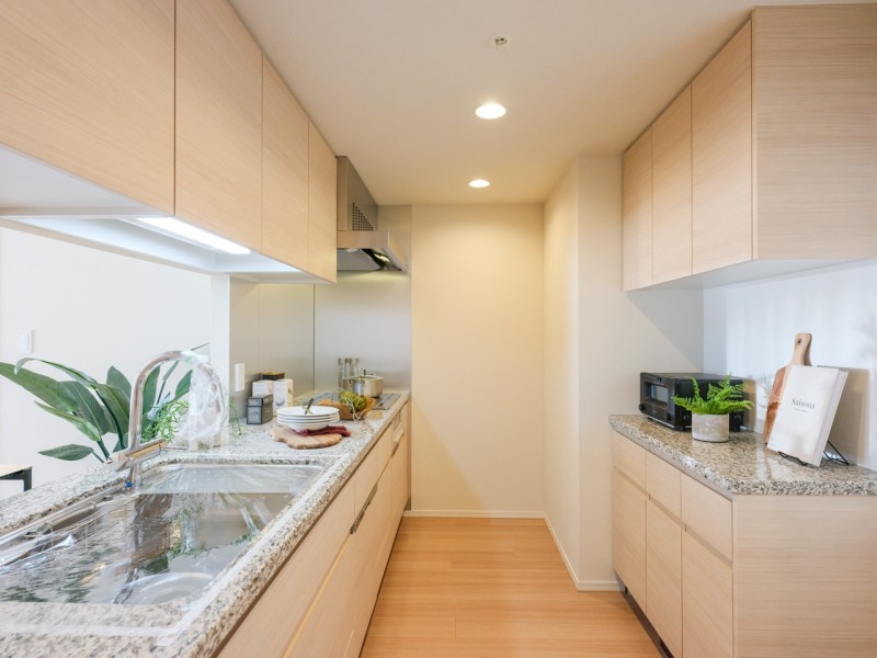 お部屋の雰囲気に溶け込み、デザイン性と機能性を兼ね備えた壁付けキッチンです。背面には収納豊富なカップボードがあります。