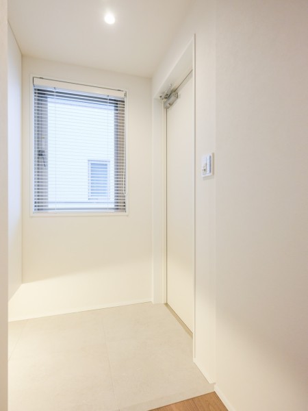住まいの顔となる玄関は明るいホワイトカラーで仕上げました。高い収納力を誇るシューズボックスを造作しましたので、ご家族みなさんの靴もたっぷり収納できそうです。