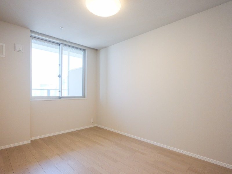 バルコニーに面した洋室1はたっぷりの自然光が降り注ぐお部屋です。窓の外には青々と広がる空が見え、都会の喧騒を感じさせない穏やかな時間が流れます。