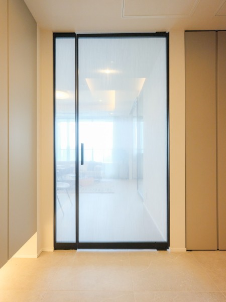 緑と青空に調和するナチュラルな内装にRaikiの建具を使用することで洗練さを追加いたしました。極限まで細く削ぎ落としたシャープなフレームデザインと、ガラス・布・石など多様な素材の組み合わせにより、洗練されたハイエンドな空間を演出しております。