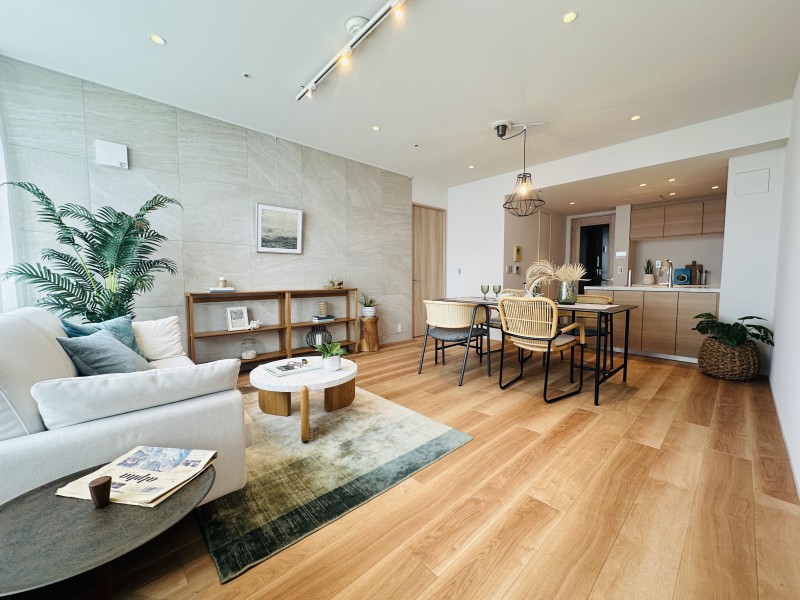 約19.1帖のゆとりあるリビングダイニングキッチンです。デザインやマテリアルにこだわり、気品と洗練を纏った居住空間です。リビング壁には、空間になじむ色合いと模様が特長のタイルを採用しました。