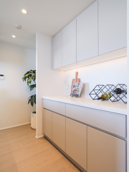 背面にはキッチンとお揃いでスタイリッシュなカップボードを備え付けました。収納が豊富にあり、料理グッズや食器などをまとめて収納できます。カウンター部分には調理家電やワインなどを置くことも可能です。