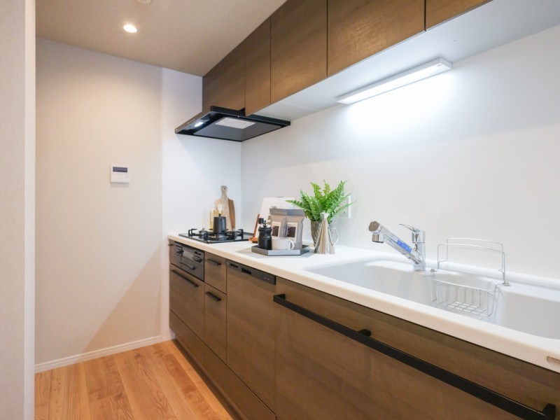 家事が捗りお手入れもしやすい壁付けのキッチンです。ゆとりある作業スペースや豊富な収納で実用的。木の温もりが漂うデザインを採用しました。