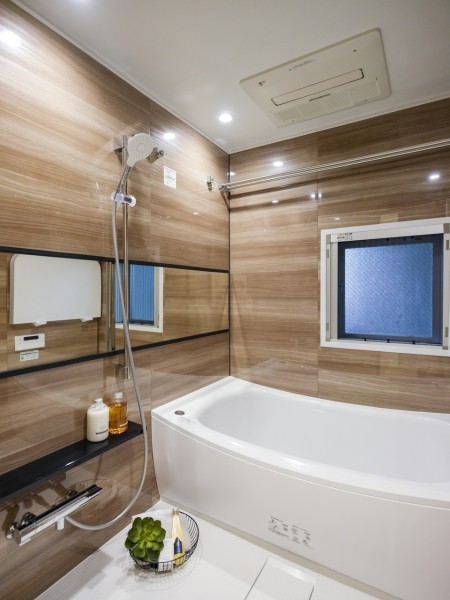 光沢のある木目調パネルが、よりいっそうくつろぎを演出するバスルームです。優雅で開放的なひとときをお過ごしいただけます。