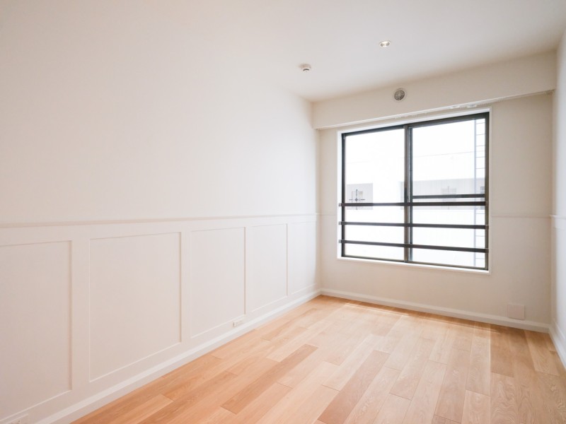 東南向きの窓から柔らかな日が差し込む洋室1です。リビングと同じ洋風な壁面も特徴的です。