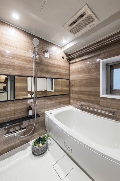 1418サイズでゆったりとおくつろぎいただけるバスルームです。光沢感のある木目調のパネルが、のびやかさと高級感を醸し出します。