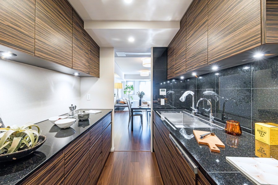 快適な家事動線が確保された壁付けシステムキッチンです。背面にはキッチンとお揃いで収納豊富でカウンタースペースも広いカップボードが備わっています。