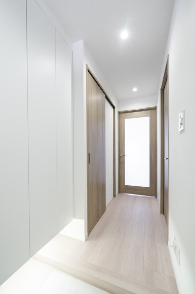 ダイニングからの光を取り込んだ明るい玄関です。天井までの高さのシューズボックス、収納棚を造作しているため、たっぷりと収納いただけます。