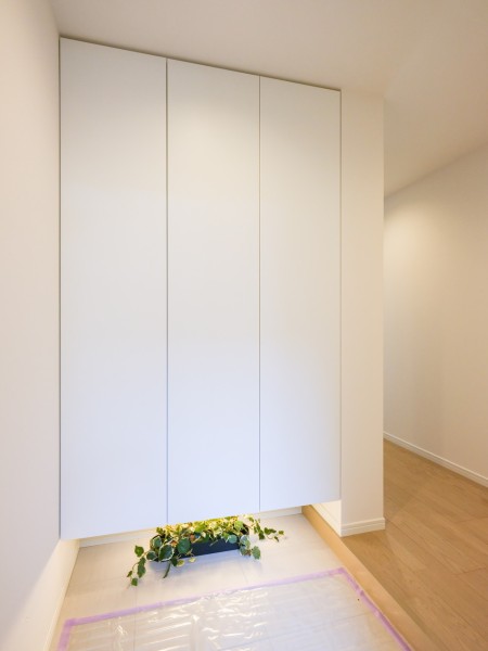 フットライト付きの明るい玄関です。天井までの高さのシューズボックスを備えたことで、玄関をすっきりとお使いいただけます