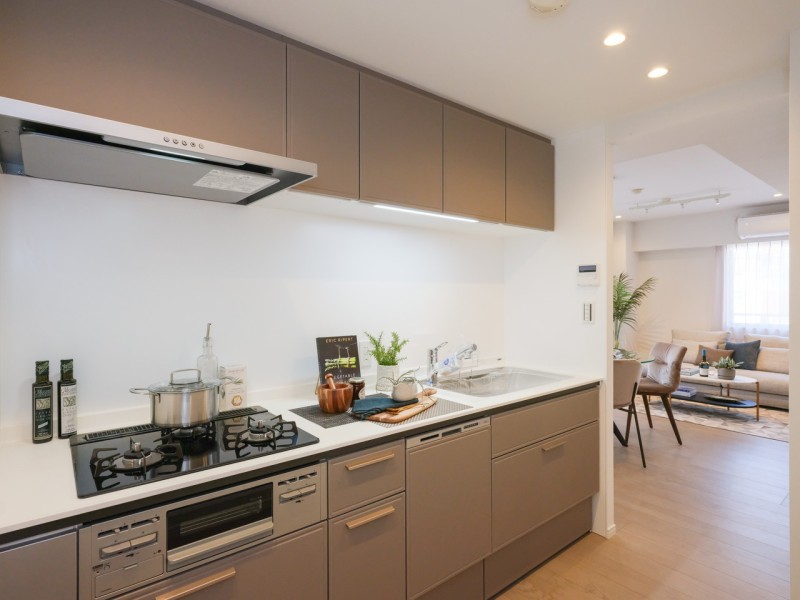 お料理に集中できる壁付けタイプのキッチン。家事時短に便利な食洗器や三口コンロ搭載です。背面には収納豊富なカップボードを備え付けました。