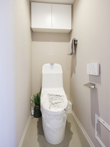 白を基調としたレストルームには上部吊戸棚の収納を設けました。トイレットペーパーや掃除用具をすっきりと収納いただけます。