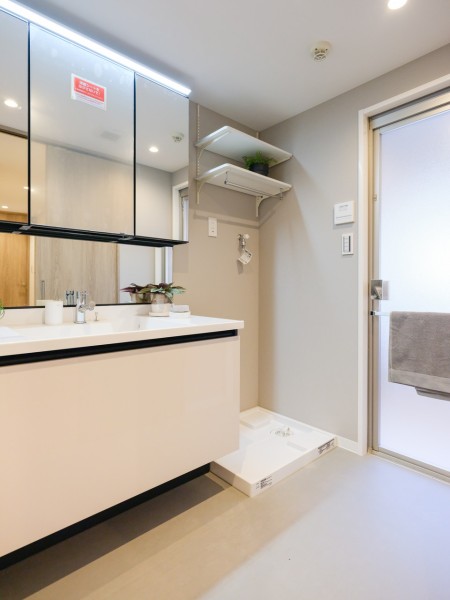 洗面室には収納豊富で実用的な洗面化粧台を新規設置しました。置場に困るタオルや着替え、ストック用品などを収納できる可動式棚を造作しました。
