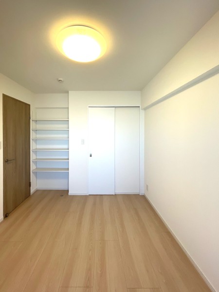 玄関から入り右手の洋室1です。ウォークインクローゼットや棚があるので居室部分は広々とお使いいただけます。
