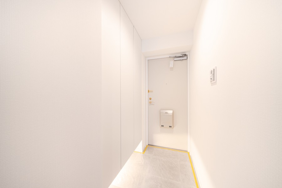 フットライトからのびる光が足元を優しく包み込む玄関です。頼もしい収納力をもつシューズボックスを備え付けました。