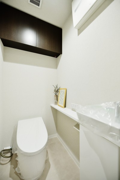 TOTO製のタンクレストイレを採用しています。タンクがない分すっきりとした空間で、上部には吊戸棚も設置し、小物やペーパー類の収納にも便利です。手洗いカンターを設置したので、清潔に保てます。