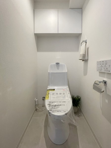 シンプルで安らぎが宿るレストルームです。大きな上部吊戸棚を設け、掃除用品やペーパー類のストックがすっきりと収納いただけます。