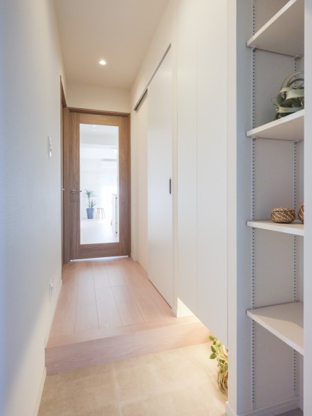 リビングからの光を取り込み、フットライトが優しく足元を照らす明るい玄関スペースです。大容量のシューズボックスと可動式収納が備わっています。