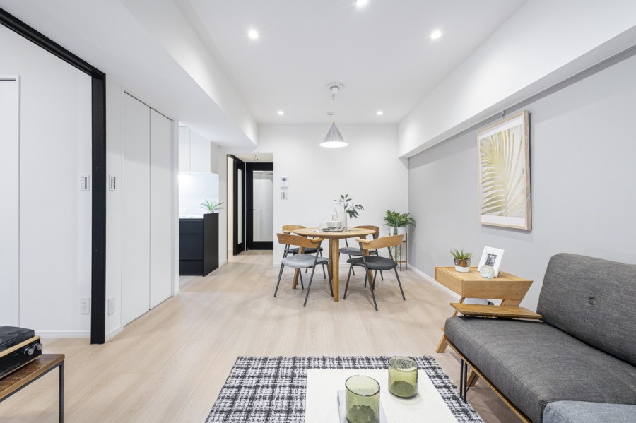 約16帖の広々としたリビングダイニングキッチンです。グレーのアクセントクロスをダウンライトが照らす上質で洗練された空間です。