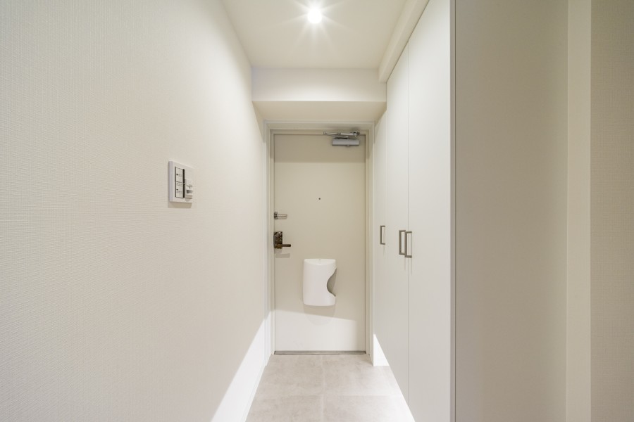 白を基調とした清潔感のある玄関です。人感センサー付きライトを設置したので、暗い時間帯のご帰宅や両手が塞がっているときも快適です。