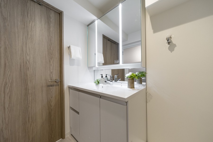 Panasonic製洗面化粧台を新しく設置した洗面室。洗濯機置場の上には便利な吊戸棚を備え付けています。