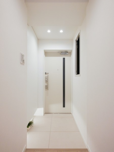白を基調とした清潔感のある玄関です。人感センサー照明のため帰宅時に暗闇の中手探りでスイッチを探す必要がなく、明るい空間が出迎えてくれます。