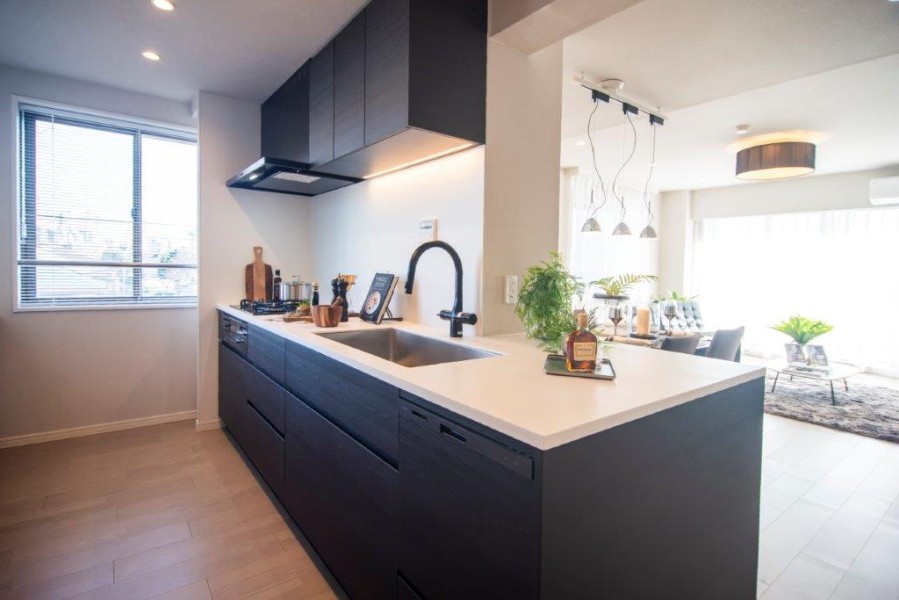 窓からの日を取り込む明るいキッチンは、室内の色合いに調和した、デザイン性の高いキッチンです。