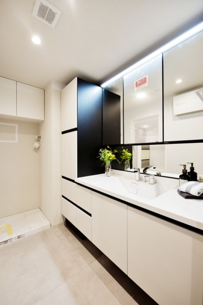 三面鏡裏やサイドキャビネットなどたっぷりと収納スペースを備えた洗面です。洗濯機置き場上部にも吊戸棚を設置しましたので、お洗濯グッズなどもしっかりと収納出来ます。