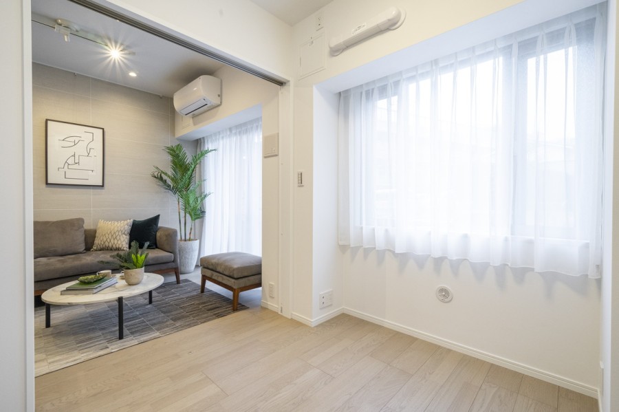 大きな窓から柔らかな自然光が降り注ぐ洋室2です。扉の開閉次第で拡張リビングとしてもお使いいただけます。