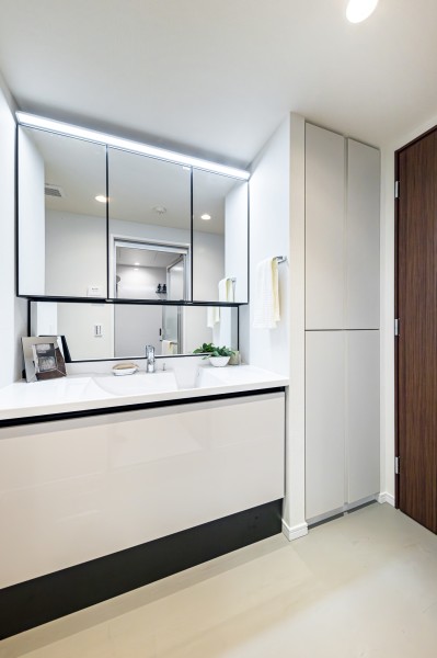 白を基調とした清潔感溢れるデザインの洗面化粧台です。洗面室にはリネン類などの収納に便利な棚を備え付けました。