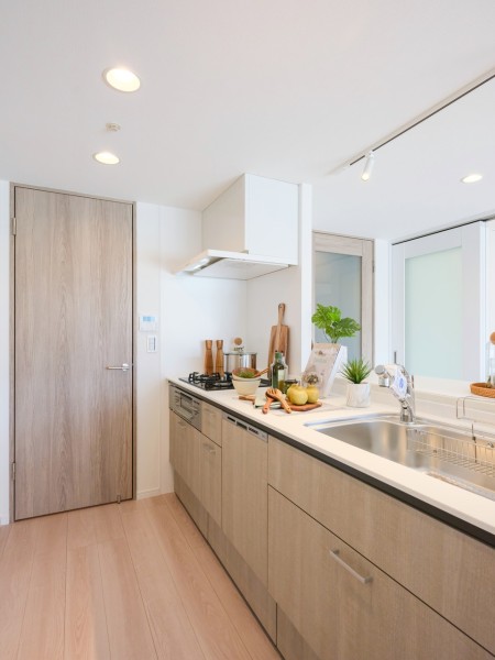 お部屋の雰囲気に溶け込む明るいオープンキッチンです。キッチン横の扉からも廊下にアクセスできるため、スムーズな家事動線を確保しています。