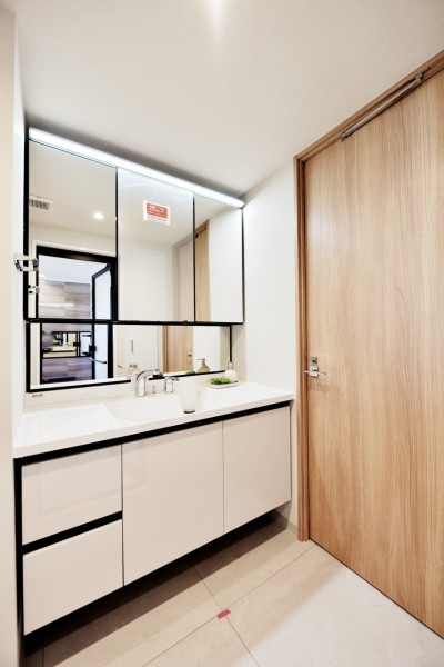 洗面台は身だしなみを整えやすい大きな三面鏡があります。鏡の裏も収納ですので、細かな物も収納しやすいですね。洗面室には吊戸棚と収納を設置しましたので、洗剤類やリネン類の収納にも便利です。