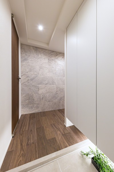 住まいの顔となる上質で気品溢れる玄関です。リビングへと続く廊下スペースには、クォーツサイトの荒々しい石模様が特長のエコカラットを採用。格調高さを演出しています。