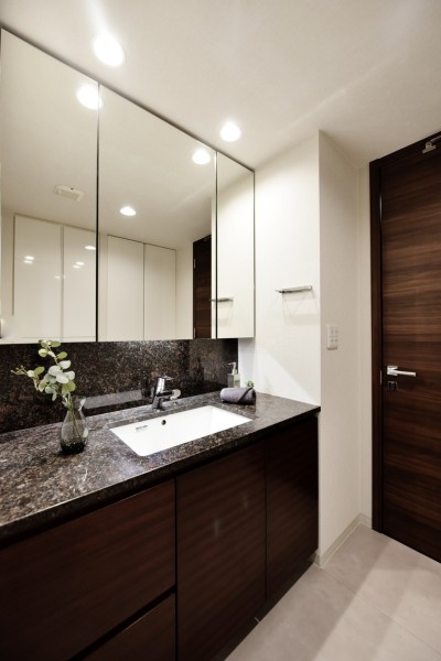 大きな鏡で身だしなみを整えやすい洗面台です。室内は色味が統一されており、高級感ある落ち着いた空間になっています。洗面室にはリネン庫もあり、きれいに整頓できます。