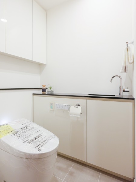 レストルームは、洗練されたお部屋にぴったりなスタイリッシュなタンクレストイレです。手洗いカウンターや収納に便利な上部吊戸棚も備え付けです。