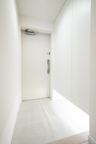 フットライトの光がやさしく足元を照らすホワイトカラーの玄関です。人感センサーライト付きで帰宅時にスイッチを探す必要がなく、明るい空間がお迎えします。