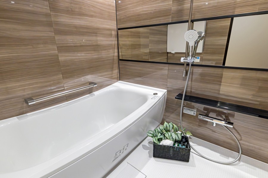 1618サイズのゆとりあるくつろぎのバスルームです。光沢感のある木目調のパネルが、より一層くつろぎと高級感を演出します。