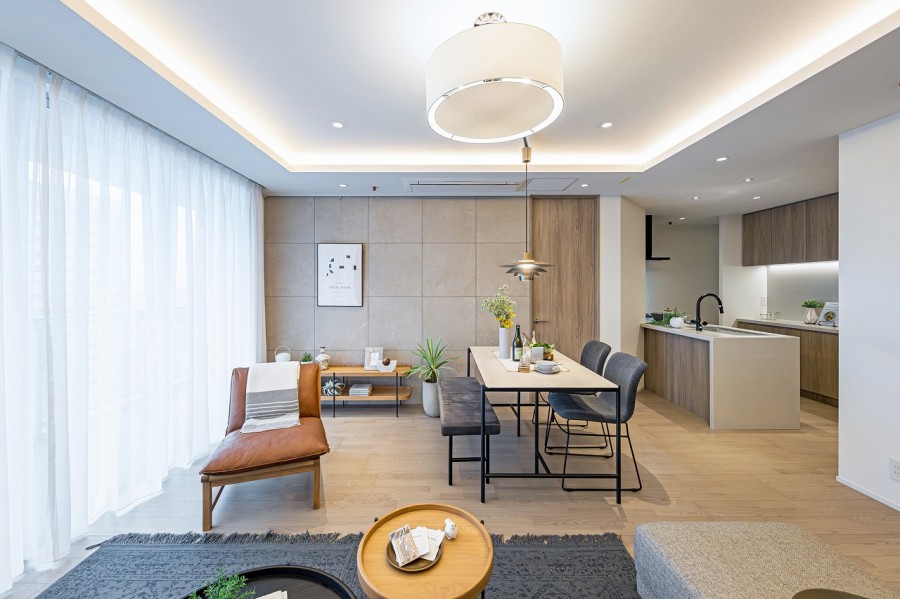 大きな窓からたっぷりの光を取り込んだお部屋です。上質なフローリングに温もりを感じ、控えめな石の流れ目と仄かに煌めく表面の石調タイルが、気品溢れる空間を演出します。