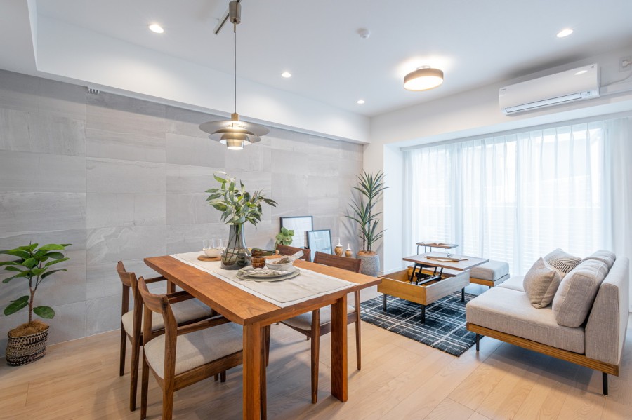 窓から注ぐ光に満たされた心地よいリビングダイニングキッチンです。控えめな石の流れ目と仄かに煌めく表面の石調エコカラットが、より一層気品溢れる空間を演出します。