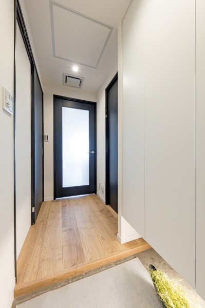 フットライトからのびる光が足元を優しく包み込む玄関です。天井までの高さがあるシューズボックスを備え付けたので、玄関をすっきり綺麗に保てます。