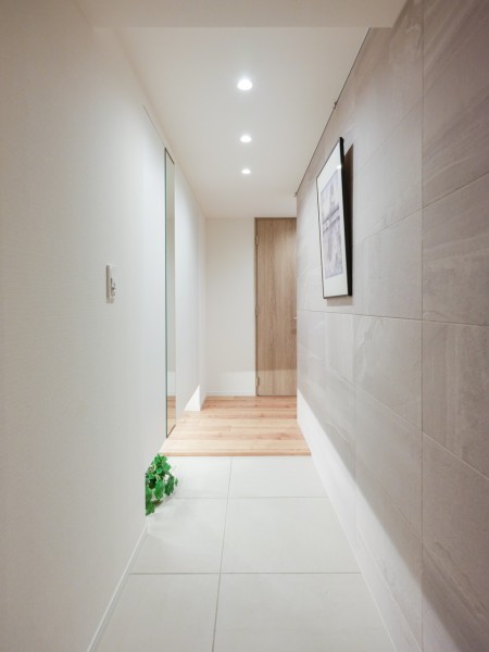 大理石調のエコカラットで高級感漂う玄関ホールです。天井までの高さがあるシューズボックスを備え付けたので、玄関をすっきり綺麗に保てます