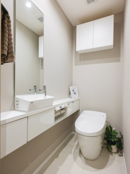 レストルームには洗練されたお部屋にぴったりなスタイリッシュなタンクレストイレが設置されています。鏡付きの手洗いカウンターを備え付け、収納スペースもたっぷりあります