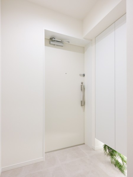 白を基調とした清潔感のある玄関です。天井までの高さのシューズボックスを備えたことで、玄関をすっきりとお使いいただけます。