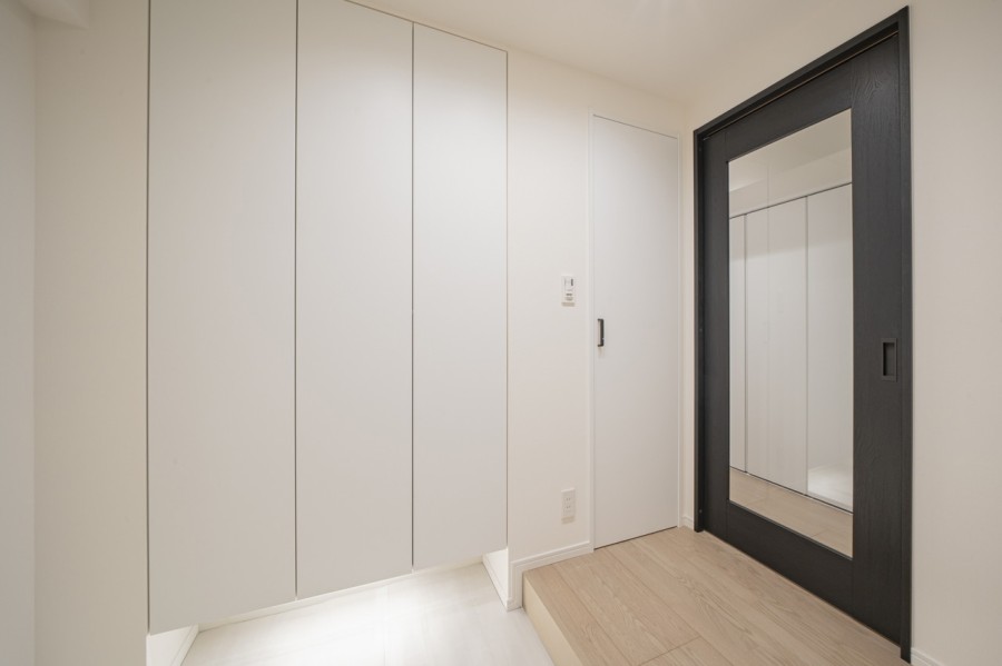 清潔感のある玄関は、フットライトからのびる光が足元を優しく包み込みます。天井までの高さがあるシューズボックスを備え付けたので、玄関をすっきり綺麗に保てます。