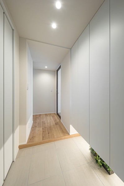 清潔感のある玄関は、フットライトからのびる光が足元を優しく包み込みます。天井までの高さがあるシューズボックスや収納を備え付けたので、玄関をすっきり綺麗に保てます。