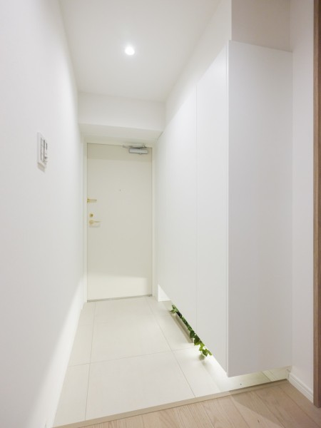 フットライトからのびる光が足元を優しく包み込む気品溢れる玄関です。天井までの高さがあるシューズボックスを備え付けたので、玄関をすっきり綺麗に保てます。