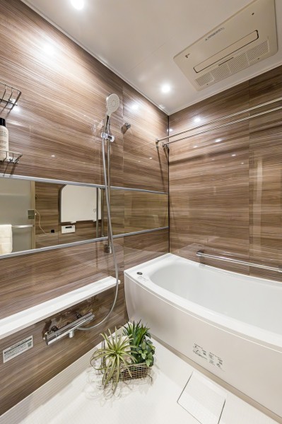 光沢のある木目調パネルが高級感を醸し出すゆったりとしたバスルーム。一日の疲れをしっかりと癒す、上質なリラクゼーション空間が広がります。